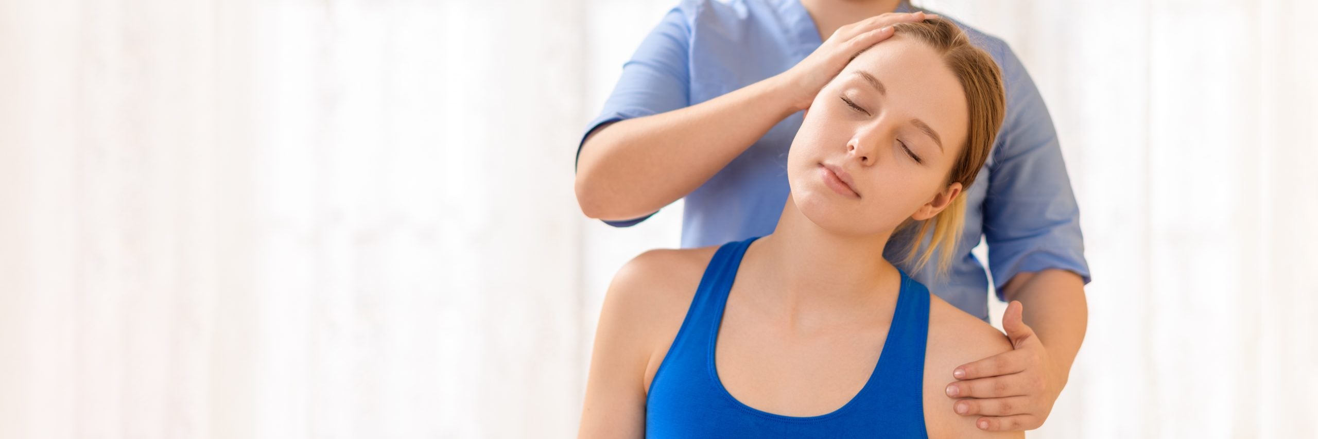 Physiotherapist assisting a woman with neck pain relief exercises, focusing on improving neck mobility and posture correction.